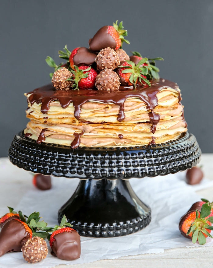 exemple de gateau de crepes avec glaçage chocolat et topping de bonbons ferrero rocher et fraises au chocolat