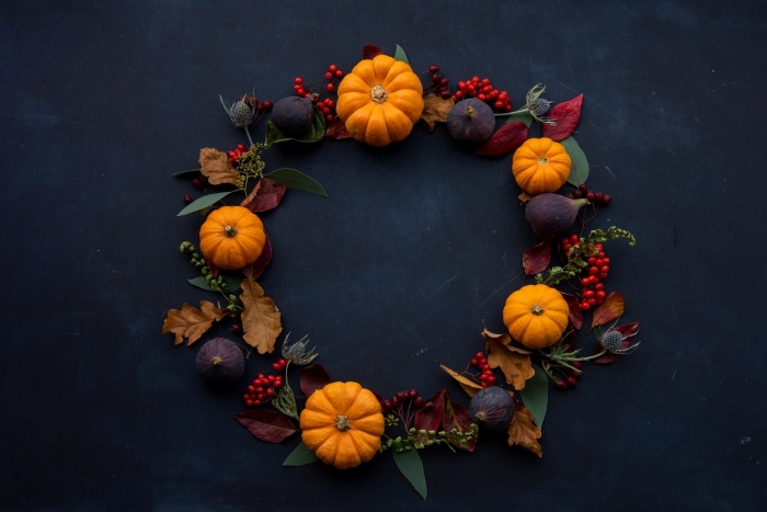 fond-d-écran-noir-pour-halloween-feuilles-séchées-colorés-fruits-séchés-guirlande-fruits-et-feuilles-pour-halloween décoration pour Halloween à faire soi même, modèle de couronne de porte Halloween faite de citrouilles et branche