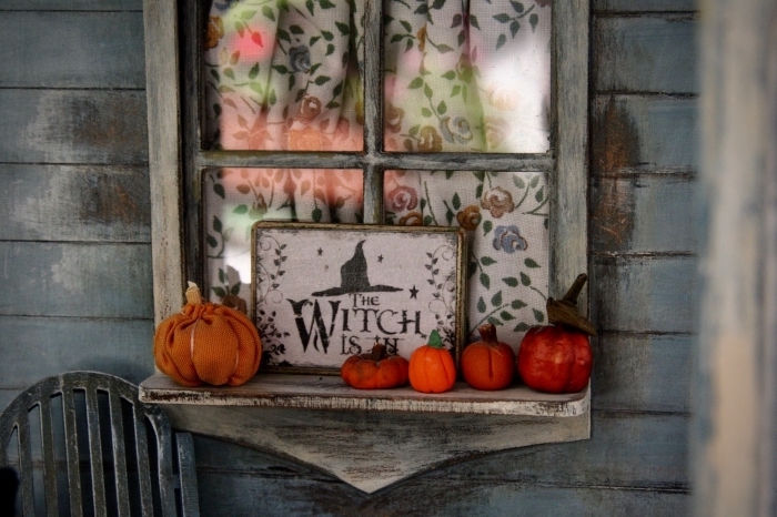 comment décorer son extérieur pour la fête de Halloween, idée déco fenêtre avec citrouilles oranges et poster sorcière