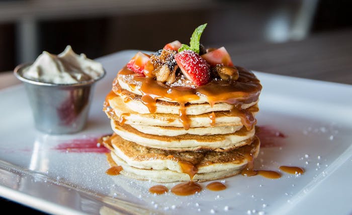 recette de pancake américain servi avec du caramel fait maison, fruits rouges et sucre glace