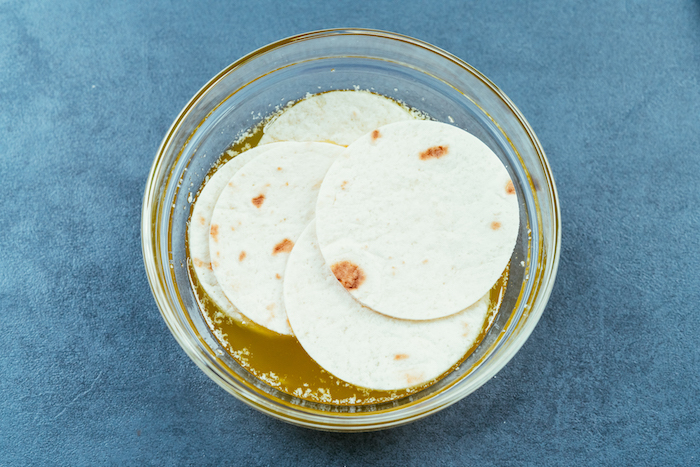 petits ronds de tortilla mexicaine trempés dans du beurre fondu, recette de tacos apéritifs au poulet et cheddar