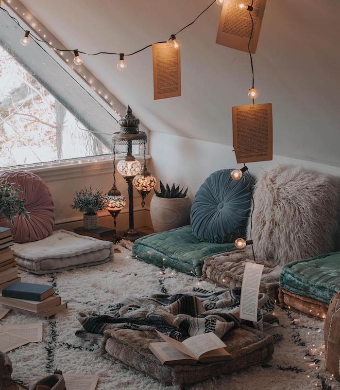 coussins d assise par sol et coussins decoratifs orientaux, tapis berbere cocooning, guirlande lumineuse, déco chambre cocooning, piles de livres, chambre de reve