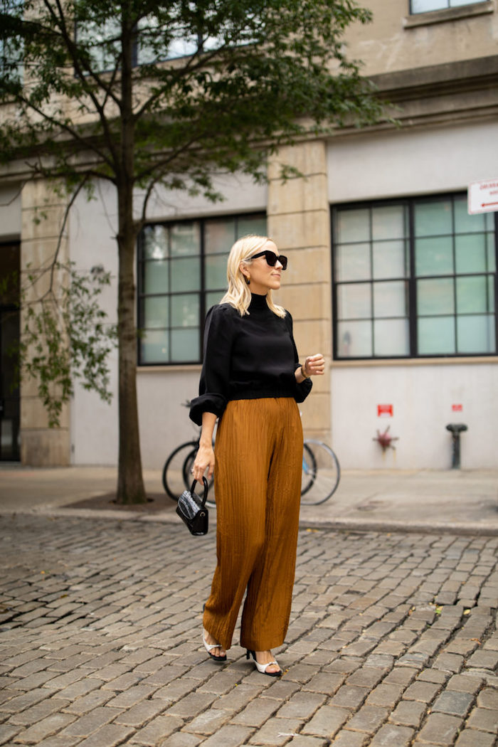 Photo inspiratrice de tenue de jour femme en automne, idée pantalon évasée et t-shirt manche longue noire, lunettes de soleil modernes