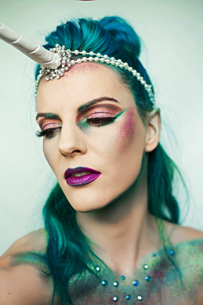 maquillage d'halloween artistique en rose, vert et violet pour un look licorne original, bijou de cheveux licorne avec perles sur cheveux bleu turquoise