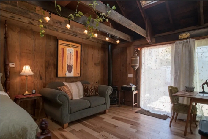 aménagement grange de style rustique, décoration chambre à coucher à design chalet bois foncé avec canapé tissu