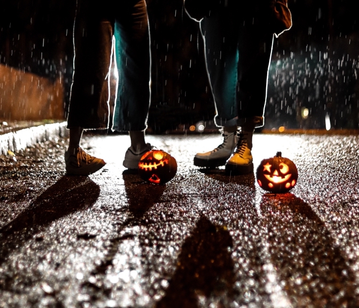 image halloween pour écran iphone, photo de teens habillés en jeans sous la pluie avec petites citrouilles sculptées
