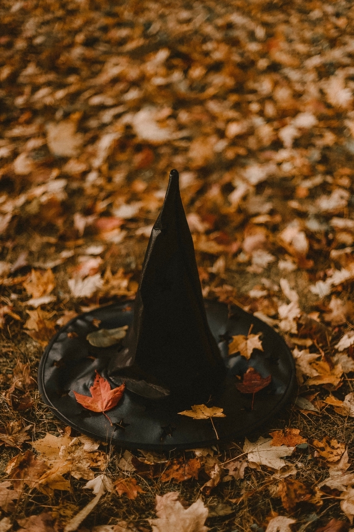 wallpaper sorcière halloween pour iphone, photo de chapeau sorcière sur feuilles séchées colorés d'automne