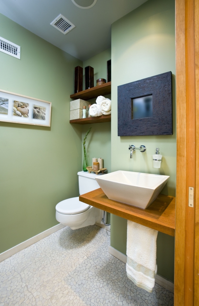 deco toilette aux murs verts et carrelage sol en blanc, idée rangement espace limité avec étagère en bois foncé