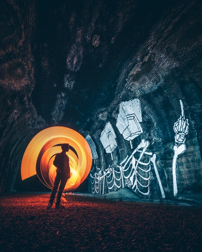 photographie abstraite, photo de garçon dans une grotte avec dessins à motifs squelettes, idée wallpaper portable pour Halloween