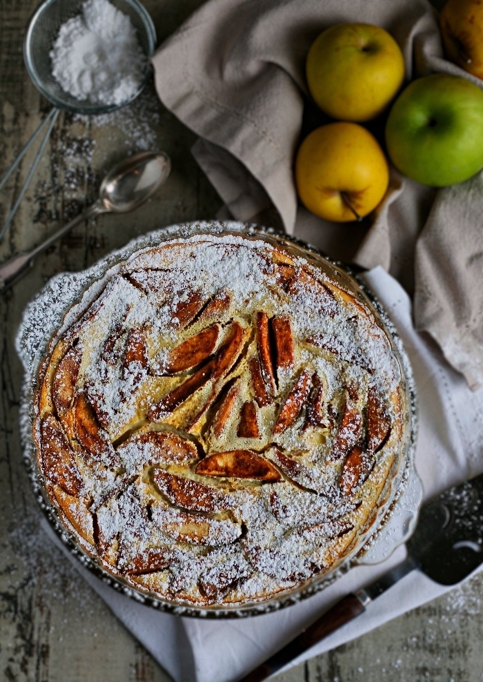 recette de clafoutis aux pommes et à la cannelle saupoudré de sucre glace, gâteau français aux pommes