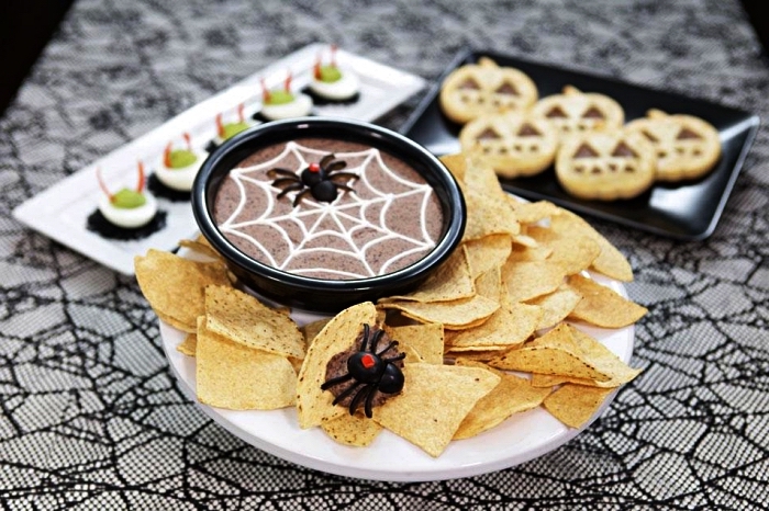 recette d'halloween facile pour préparer du houmous aux haricots noirs, houmous toile d'araignée servi avec chips tortillas