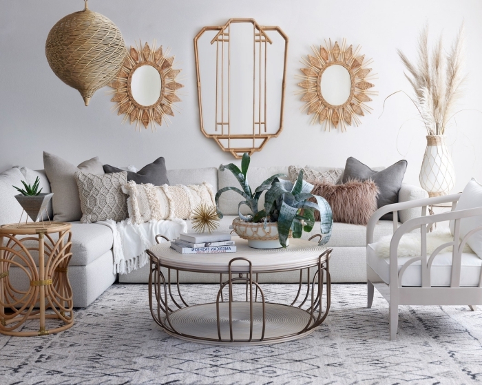 décoration de salon aux murs blanc aménagé avec canapé et table basse métal, modèle de table café en rotin, miroir en forme soleil
