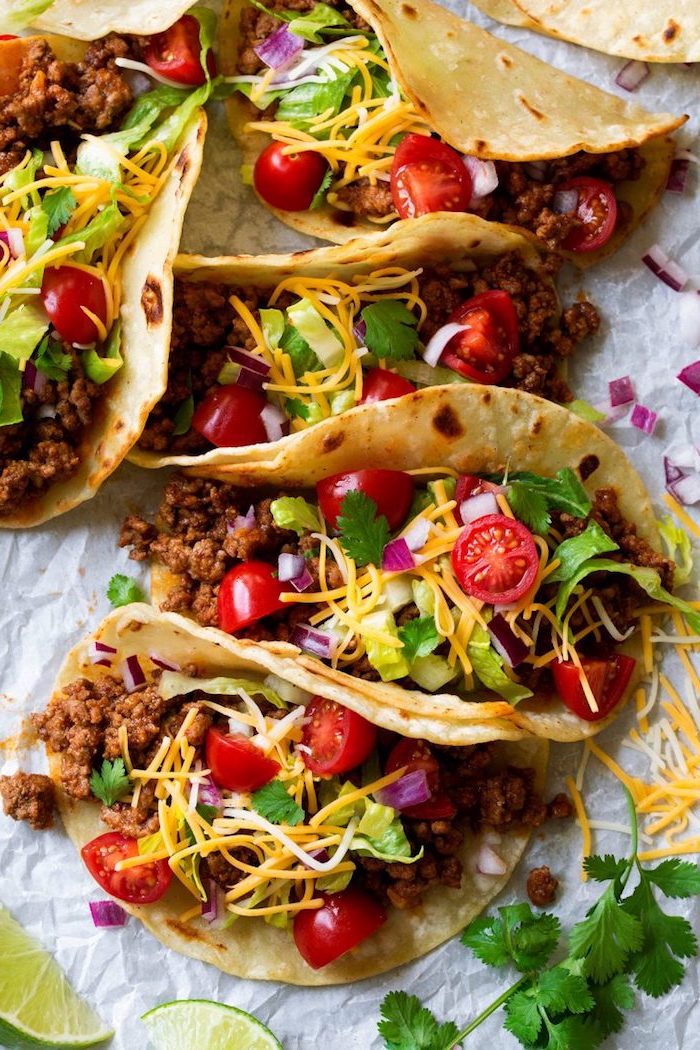 recette tacos maison à la viande de boeuf, cheddar râpé, tomates cerises et persil, wraps de tortillas mexicains parfaits pour une entrée facile et rapide