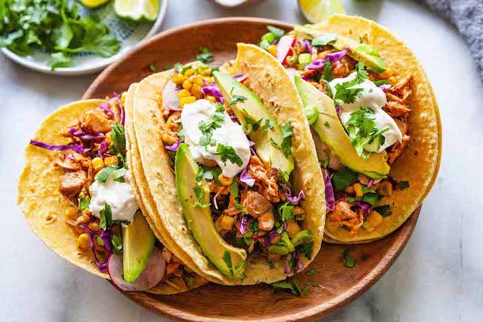 Idée recette rapide pour l'été, recette de tacos mexicains au poulet garnis de tranches d'avocat, de maïs et de chou rouge