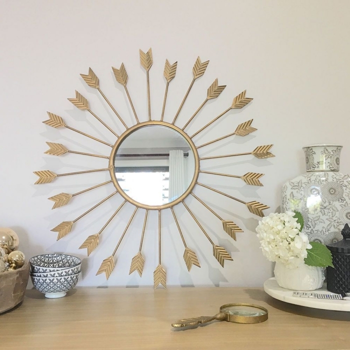 décoration de salon moderne aux murs blancs avec armoire en bois clair et objets ethniques, modèle miroir ovale doré
