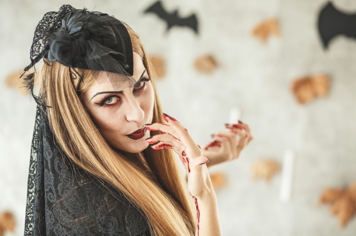 look d'Halloween pour femme, idée tenue vampire avec robe noire et accessoires cape et cheveux en dentelle