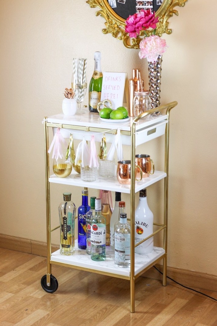 desserte ikea marbre et or sur un parquet bois, idee mini bar diy amovible avec boissons, verres, decoration de pompons à frange
