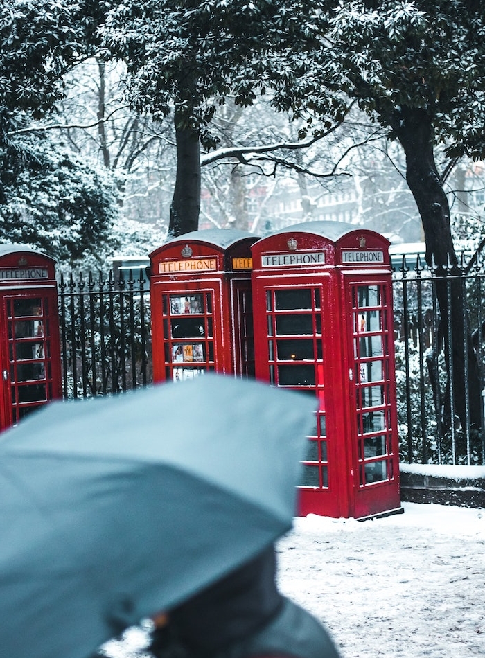 ville enneigée, image prie dans les rues de londres, arbres en neige et cabines à téléphone londoniennes
