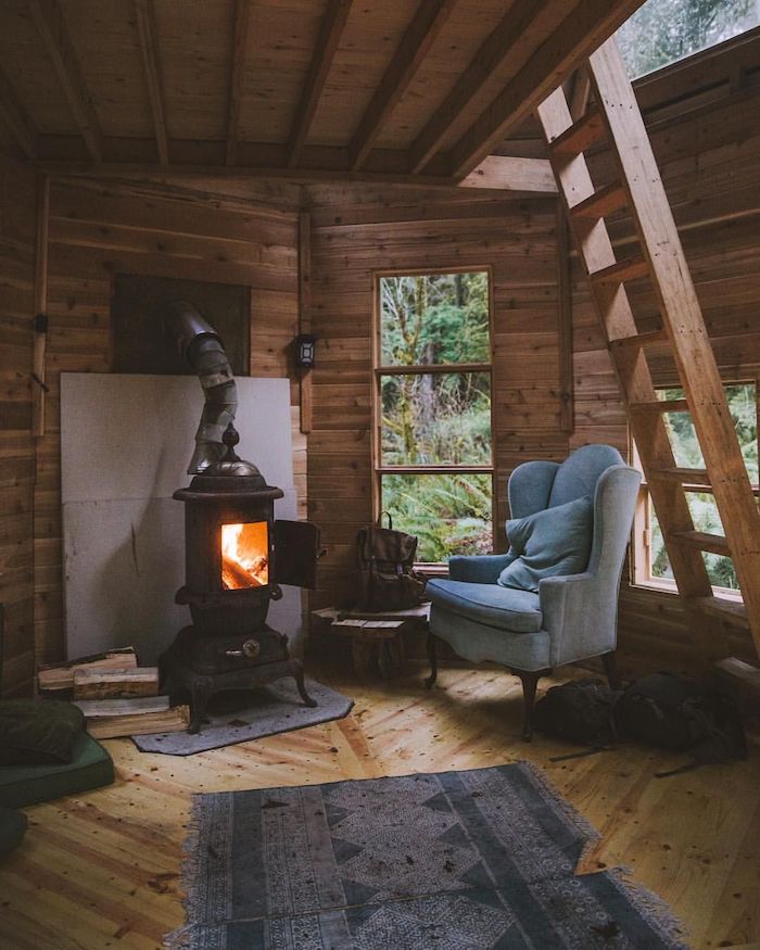 Cosy coin lecture avec fauteuil gris confortable près de la cheminée, decoration bois, deco montagne inspiration interieur chalet
