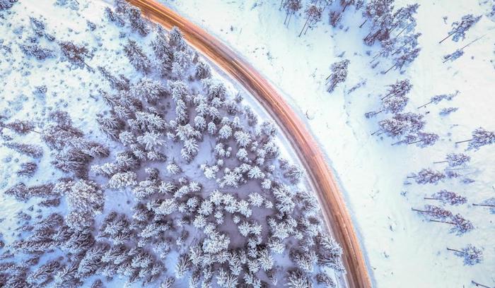 vue d en haut d une autoroute qui passe à travers une forêt de sapins avec une couche épaisse de neige