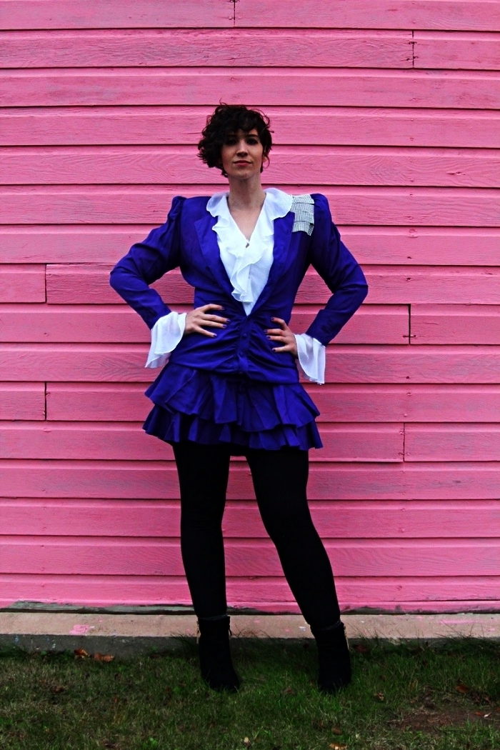 costume année 80 composée de veste, chemise blanche avec froufrous, jupe à volants violette et legging noir