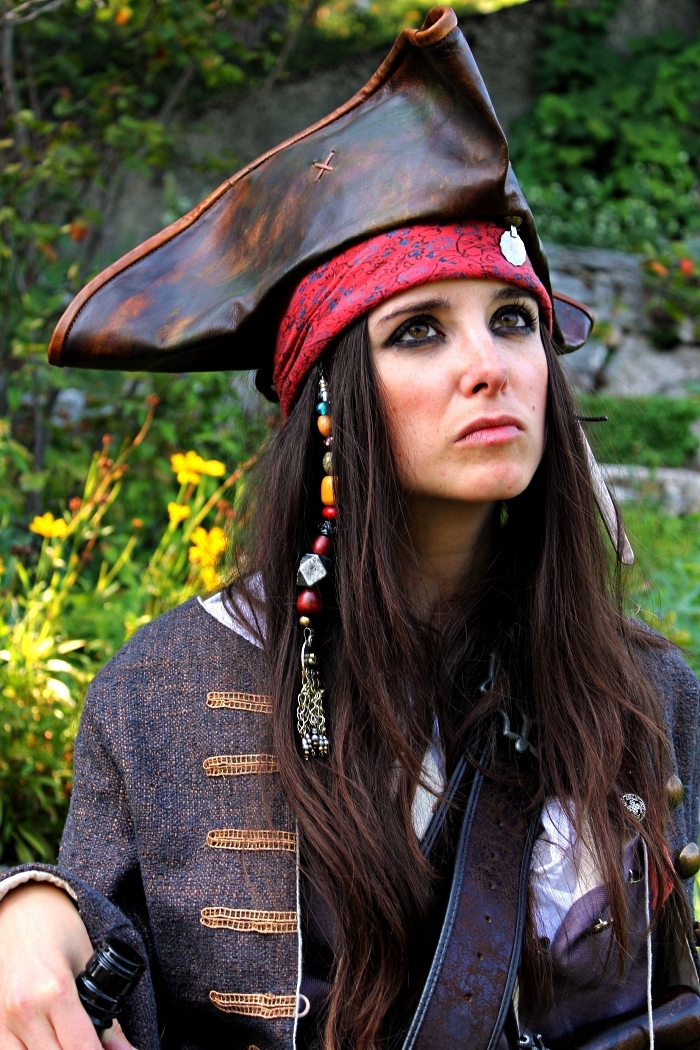 déguisement pirate femme avec chapeau en cuir, mèches à breloques et maquillage de pirate avec crayon noir, déguisement de jack sparrow pour femme