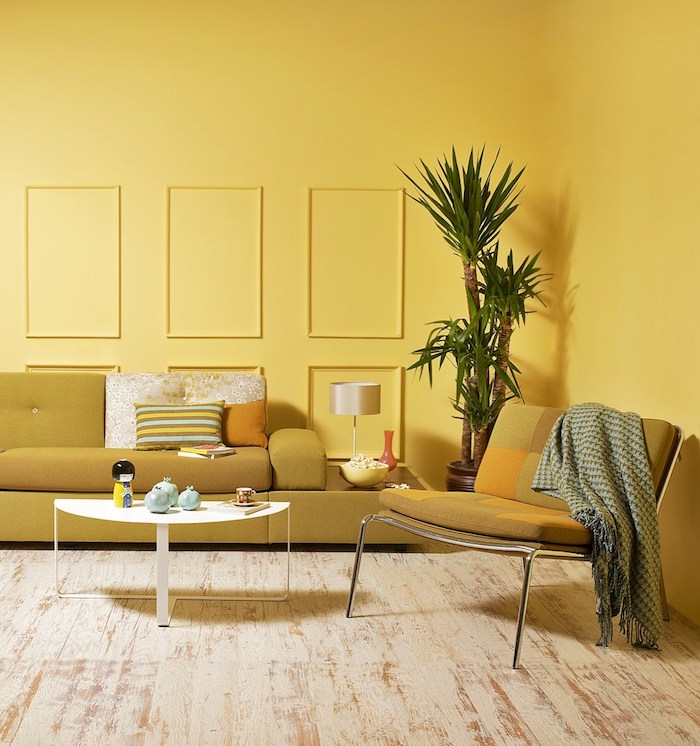 décoration peinture salon jaune avec canapé jaune de gris, table basse scandinave blanche sur parquet bois patiné