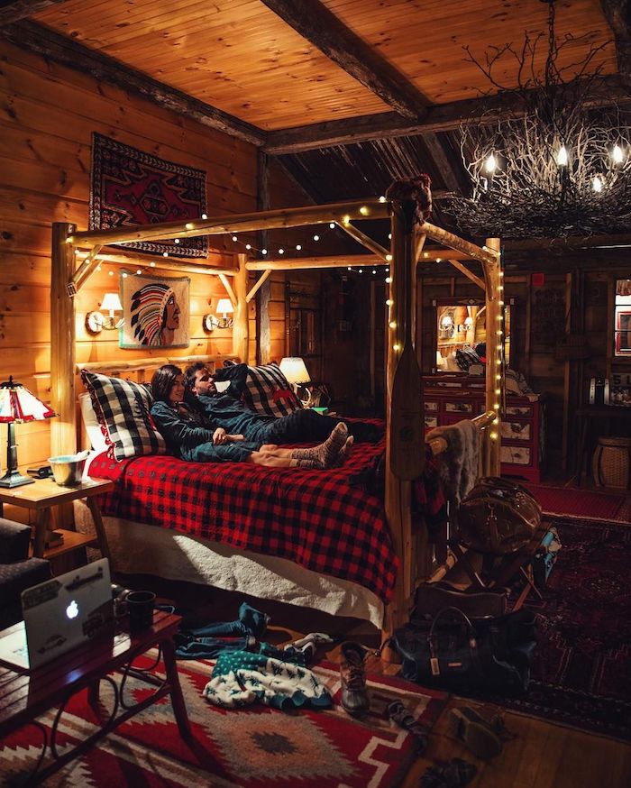 Couple déco chambre cocooning, deco rustique dans un chalet chic, lit avec guirlande lumineuse autour, déco de noel chalet