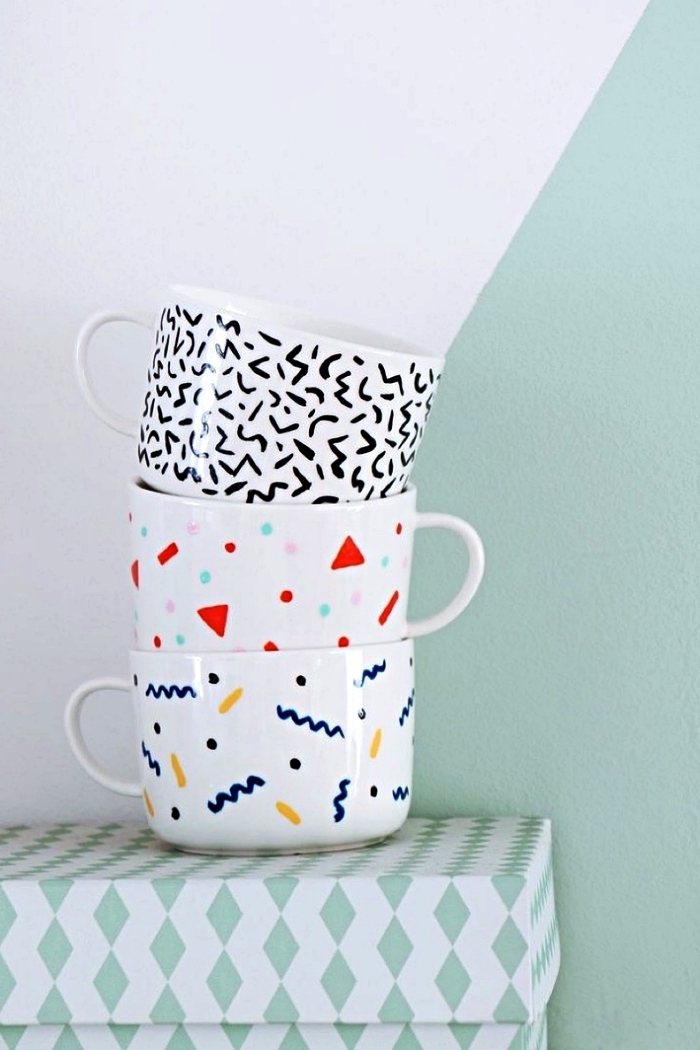 décorer des mugs blancs au feutre pour porcelaine, trois tasses à café à motifs graphiques modernes