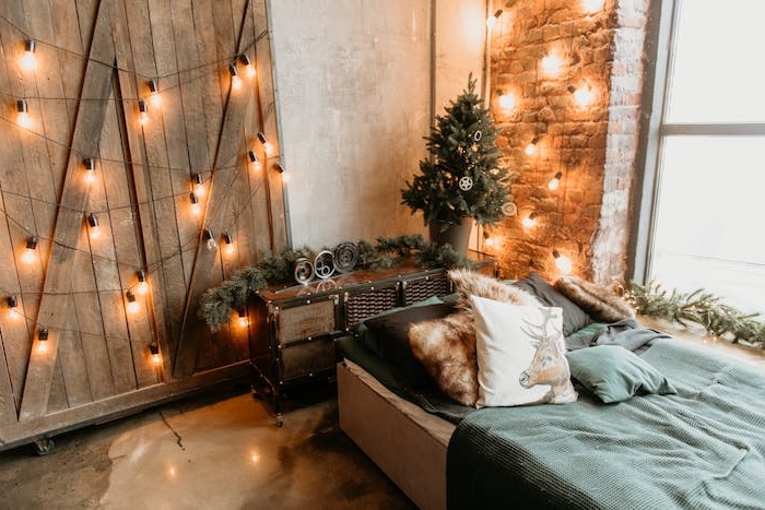 deco chambre cocooning avec lit décoré de linge de lit vert, coussins et guirlande boule pour decorer les murs et la porte