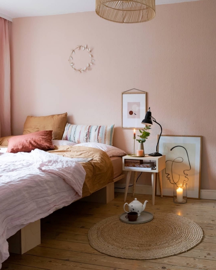 comment aménager une pièce cocooning avec tapis et lustre en fibre végétale aux murs rose pale et plancher bois