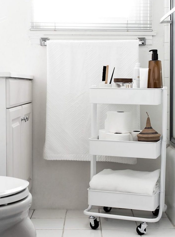astuce rangement salle de bain avec desserte blanche pour ranger serviette, rouleaux de papier toilette et produits beauté