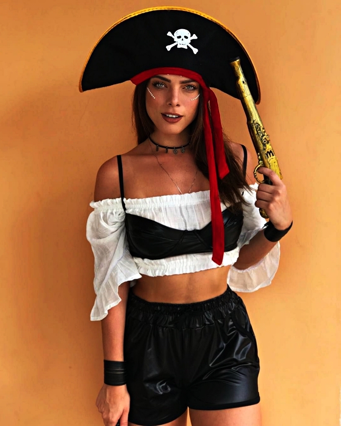 déguisement pirate femme composé d'un haut court aux épaules dénudées, short en cuir et chapeau de pirate