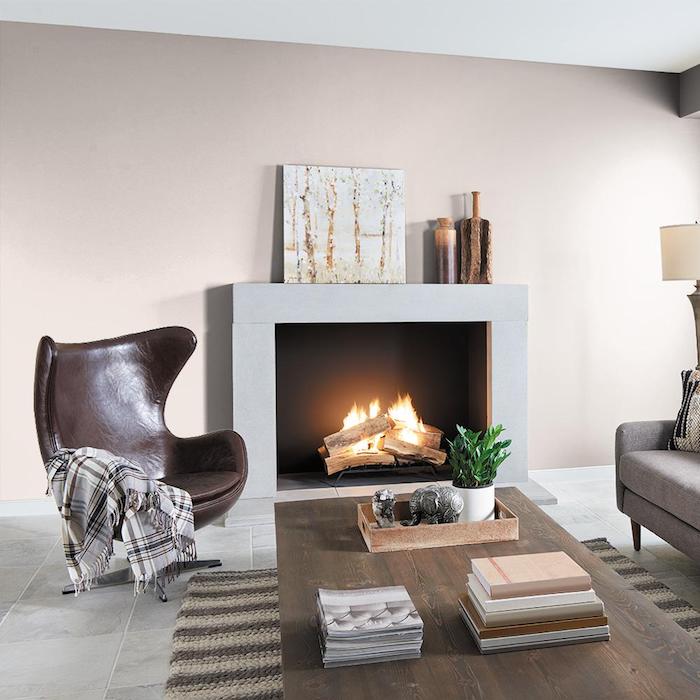mur coouleur grege, deco minimaliste salon moderne et cosy, fauteuil marron foncé, table bois foncé, cheminée moderne et canapé gris