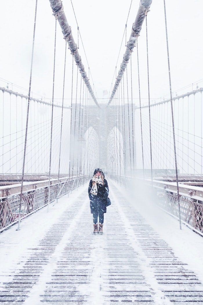 un grand pont dans ville americain enneigé avec femme vetue de vetements hiver chauds