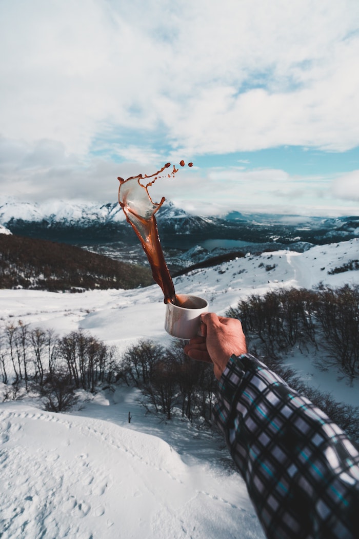 tasse de café sur fond une plaine et montagnes couverts de neige, tendance photo café avec vue, photographie dynamique