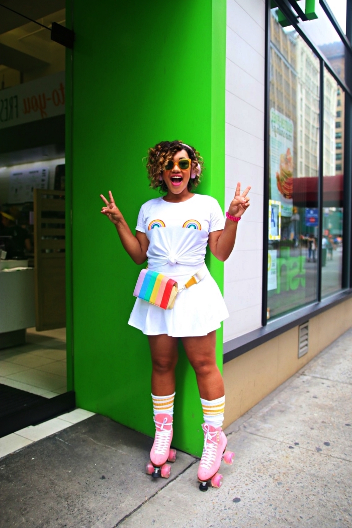 déguisement disco femme composé de jupe patineuse, t-shirt arc-en-ciel et patins à roulettes