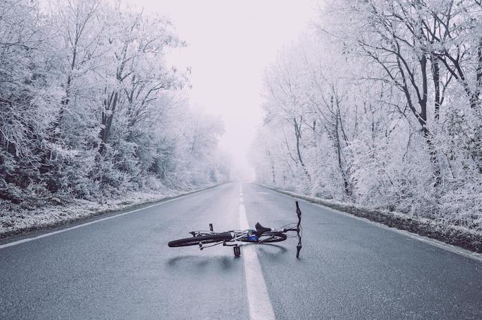 vélo abandonné au milieu d une autoroute désert bordée d arbres enneigés, exemple paysage d hiver féerique