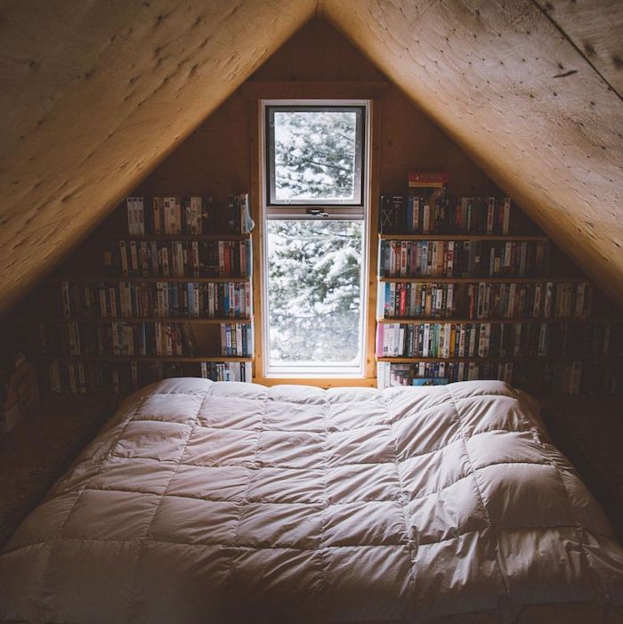Bibliothèque construite dans le mur d'un chalet, chambre à coucher cosy lit et livres, deco montagne chic intérieur dans petit maison