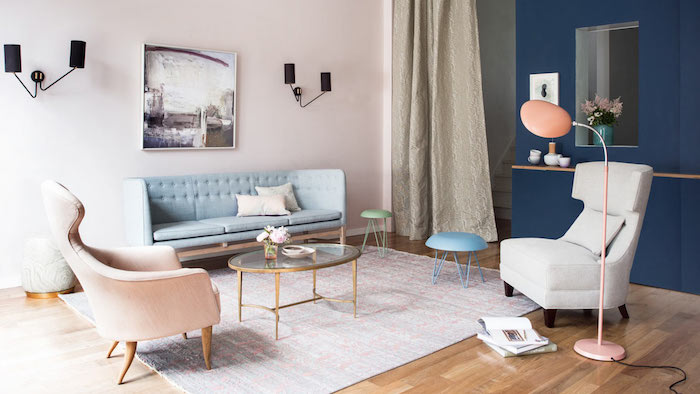 mur de fond bleu foncé et mur rose pastel dans un salon en couleurs pastel, fauteuil gris, canapé bleu pastel, parquet bois style scandinave