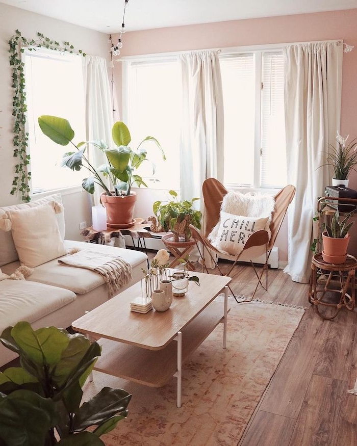 deco junge salon cocooning en peinture rose clair, chaise marron, canapé blanc, table basse bois sur tapis marron clair, plantes vertes d interieur