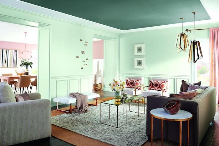 peinture couleur menthe dans un salon cocooning intimiste, canapé gris, table basse verre et metal, fauteuils blanc, coussins rouge et blanc, plafond vert foncé