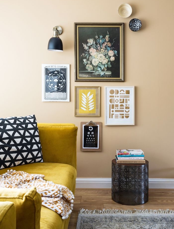 mur couleur taupe décoré de tableaux d art contemporain, canapé jaune, tapis gris sur son en parquet bois, idée peinture mur salon