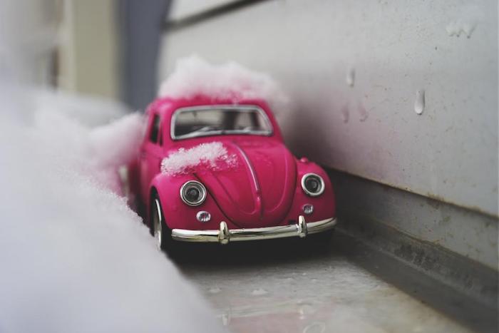 jouet voiture rouge avec neige dessus et à coté, idee image de neige original pour fond d écran