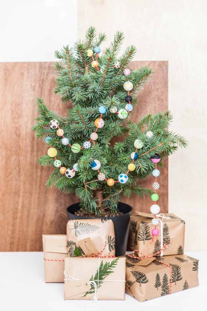 activité manuelle noel facile, idée comment décorer un petit arbre de Noël avec ornements diy en forme de guirlande en perles de bois