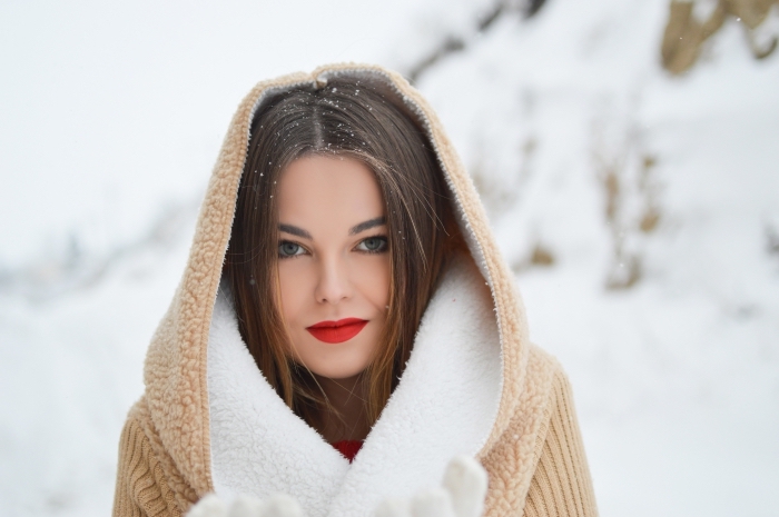 maquillage simple de Noël avec rouge à lèvre mat, look Noël femme habillée en pull rouge avec manteau beige