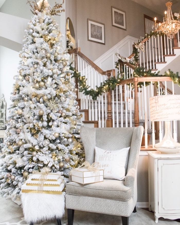 modèle gros arbre de Noël artificiel aux branches blanches décoré avec guirlandes et ornements en argent et or