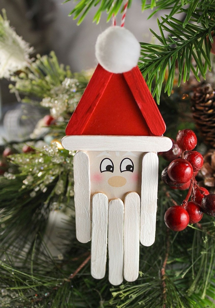 modèle d'ornement pour sapin de Noël fait maison avec rondelle bois et bâtonnets de glace en forme de tête de père noel 