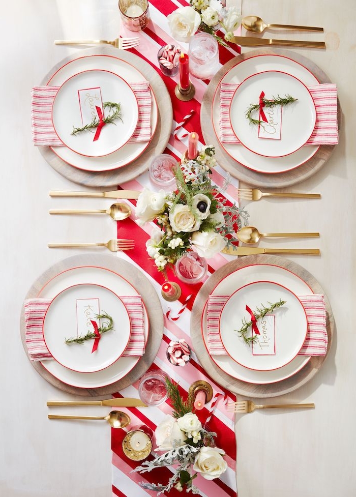 bouquets de fleurs, porte bougies et coupelles avec bonbons sur un chemin de table tissu rouge et blanc, couverts dorés, décoration de noel à fabriquer pour adultes