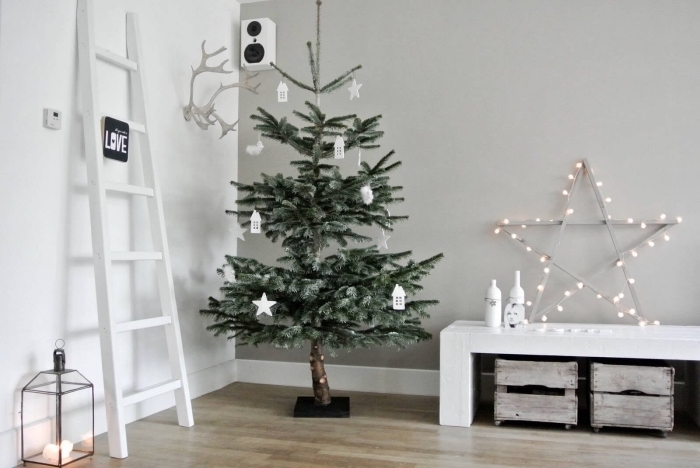 exemple comment decorer un sapin de style minimaliste avec ornements en blanc, salon scandinave aux murs en blanc et gris